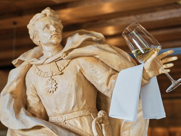 Ein Glas Wein in der Hand einer männlichen Statur
